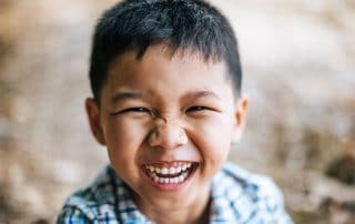 Young Asian boy showing off his big, wide smile
