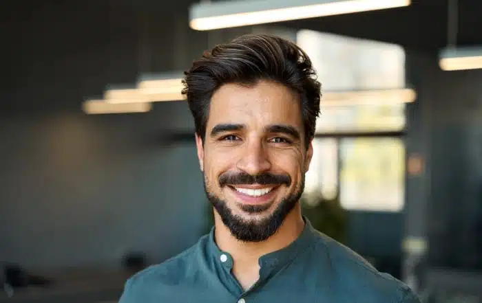 man in blue button up shirt smiling with teeth